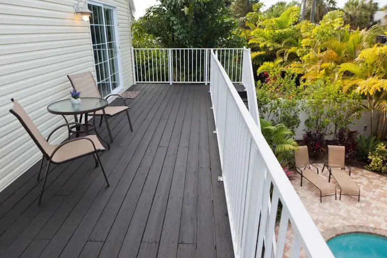 Upper deck with bistro table overlooking the pool and palms, Happy Island Cottage