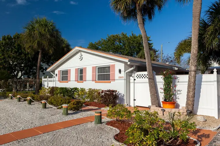 Happy Turtle duplex front exterior with coral shutters on Avenue C, Bradenton Beach